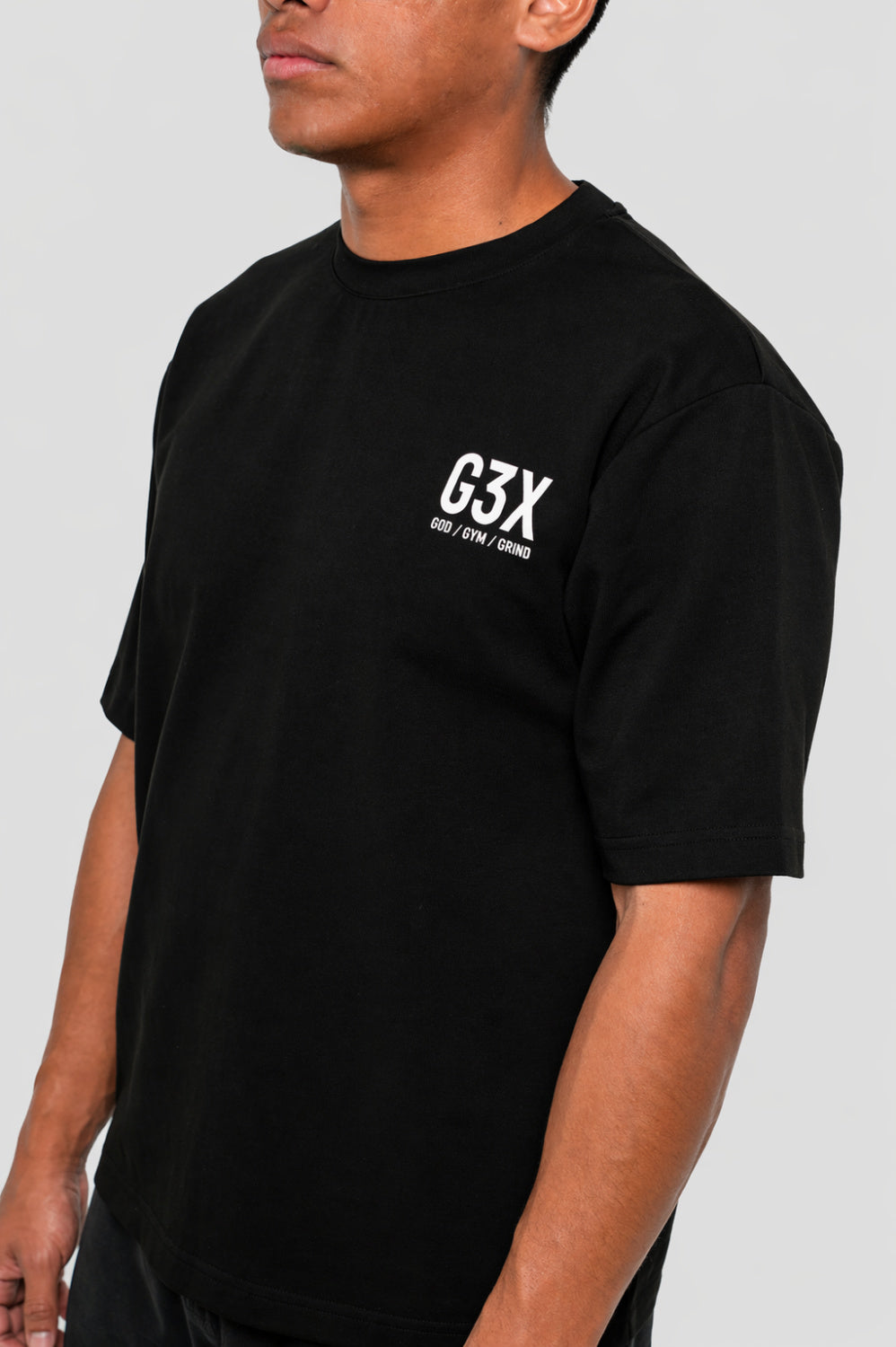 Person wearing a black t-shirt with 'G3X' logo on a plain background
