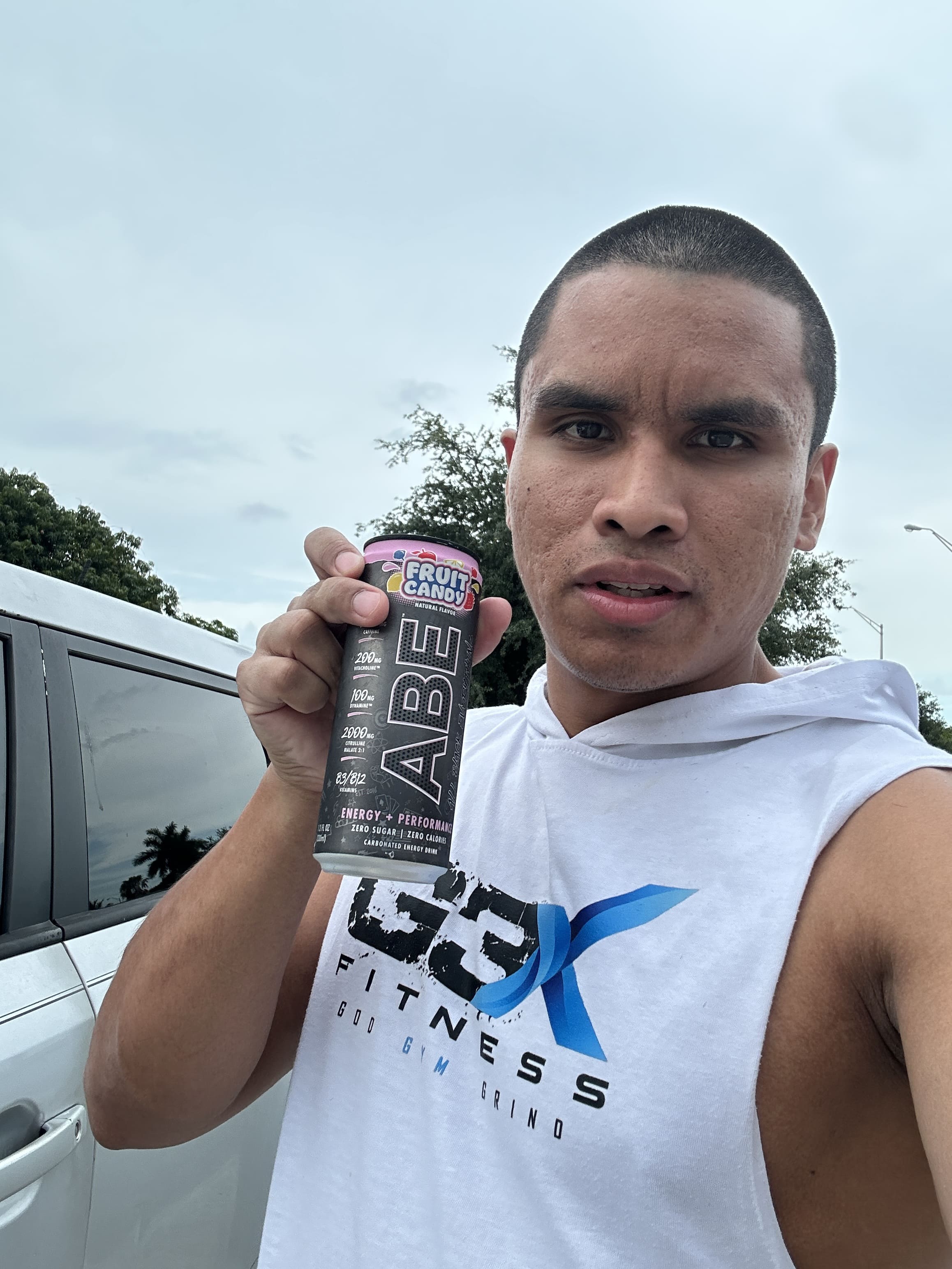 Adriel Founder G3X Fitness holding ABE Pre workout can in a white G3X Tank top