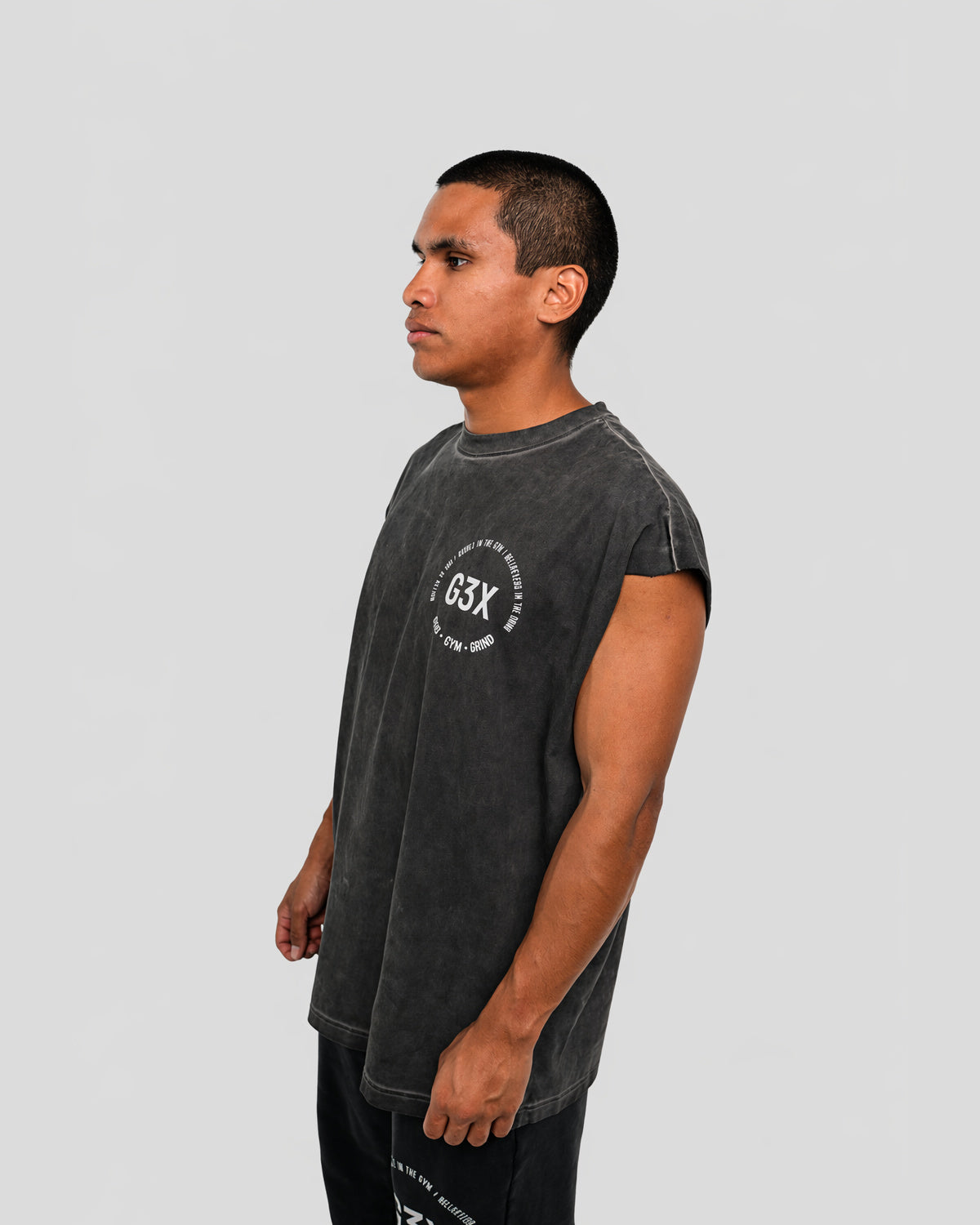 Man wearing a black G3X t-shirt with a logo on a background
